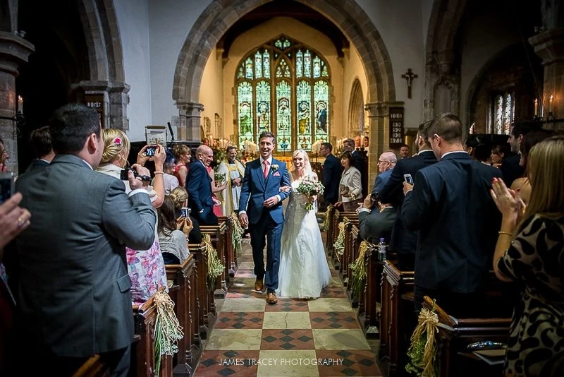 bride and groom walking out of church in hathersage