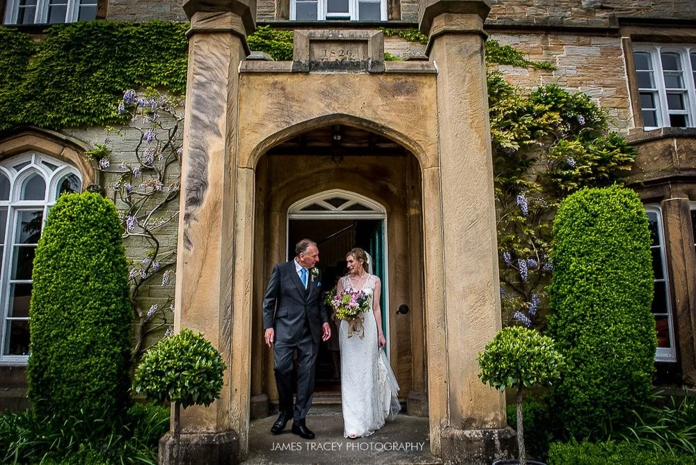 bride and her dad walking out of dunstan hall