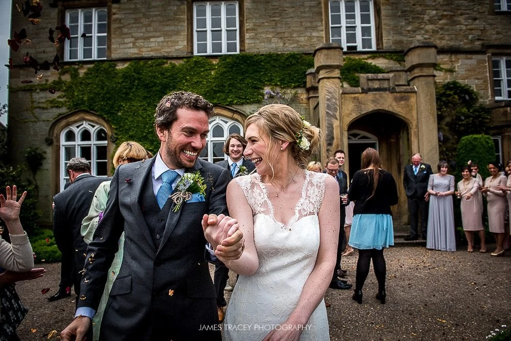 bride and groom laughing under confetti