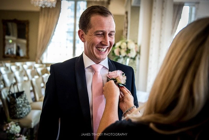 groom having flower placed on