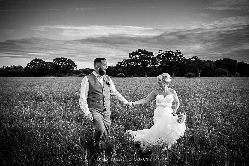 bride and groom walking back through field