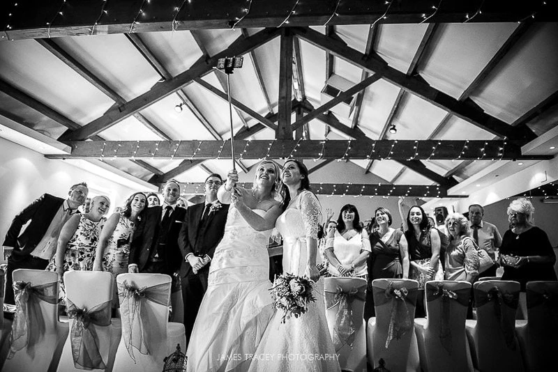 brides taking selfie at bottom of the ailse