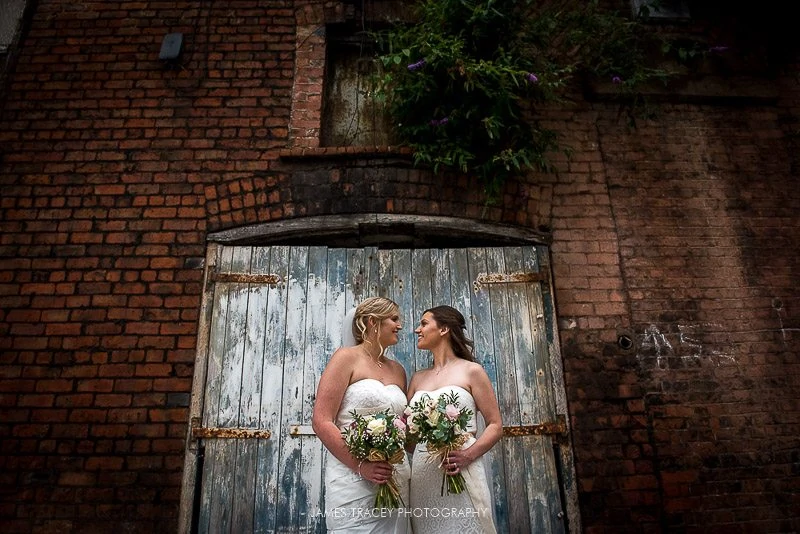 same sex wedding in front of wall