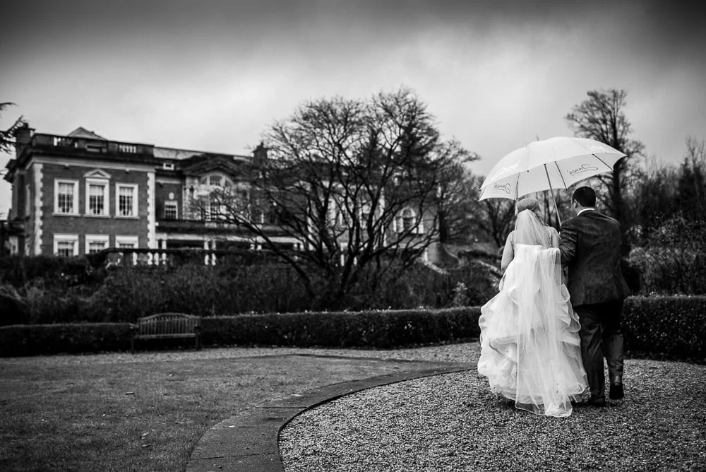 bride and groom walking back to eaves hall