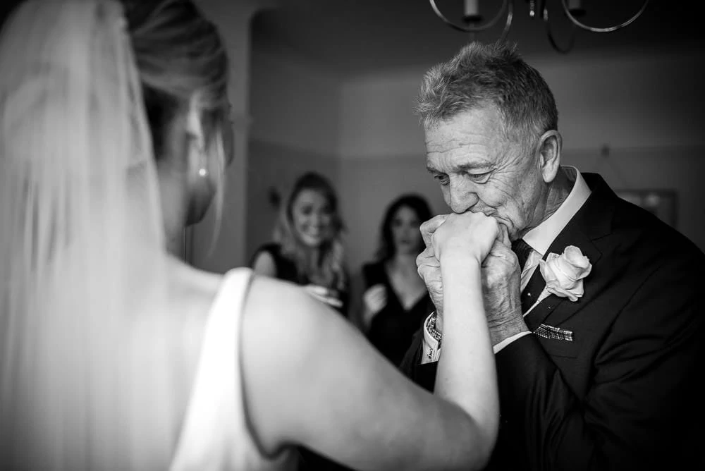 fathre of the bride kissing his daughters hand