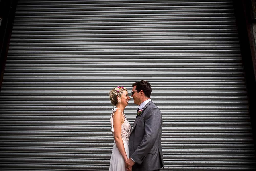 bride and groom in front of shutters