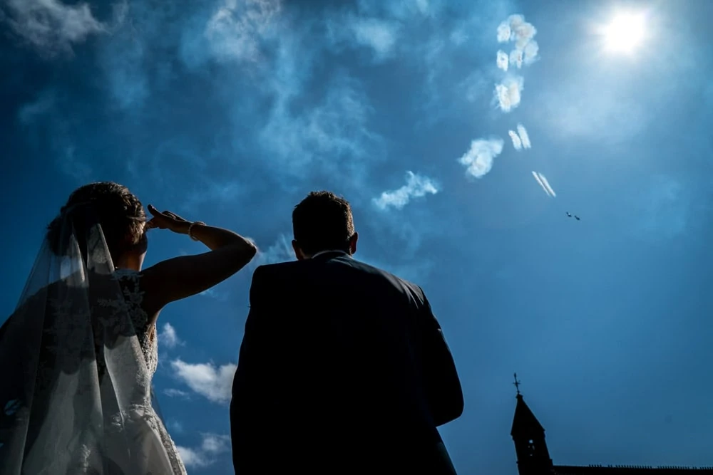 bride and groom watching acrobatic display over Peckforton Castle Wedding