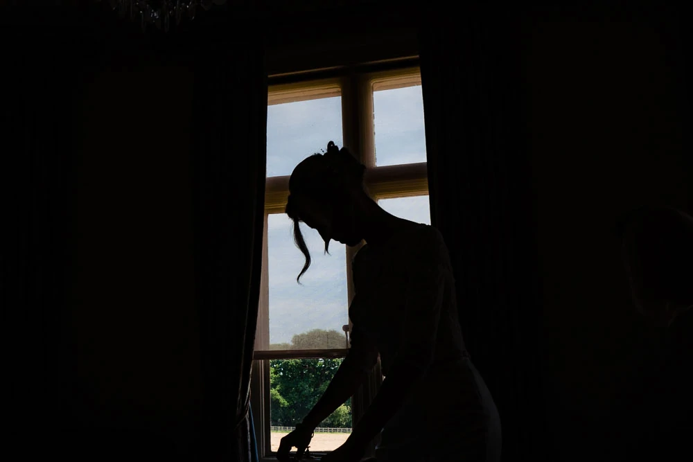 bride silhouetted against a window