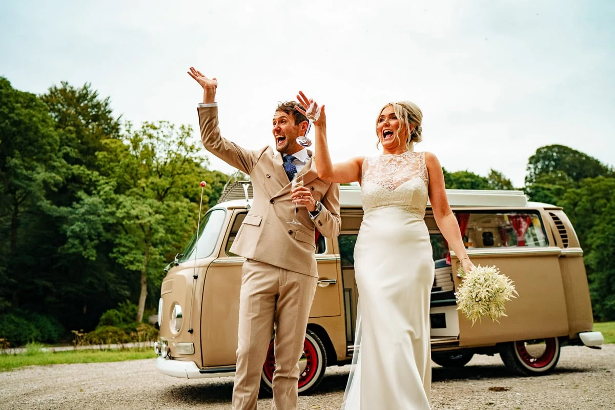 bride and groom waving at guests