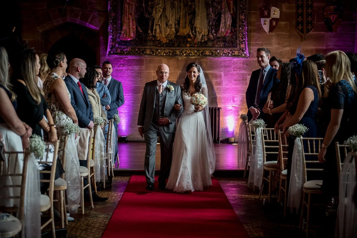 bride walking up the aisle at peckforton castle wedding