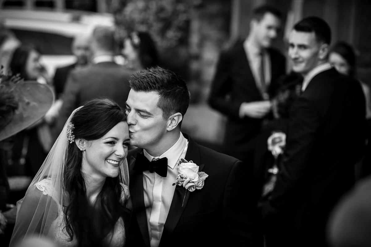 groom kissing bride at their peckforton castle wedding