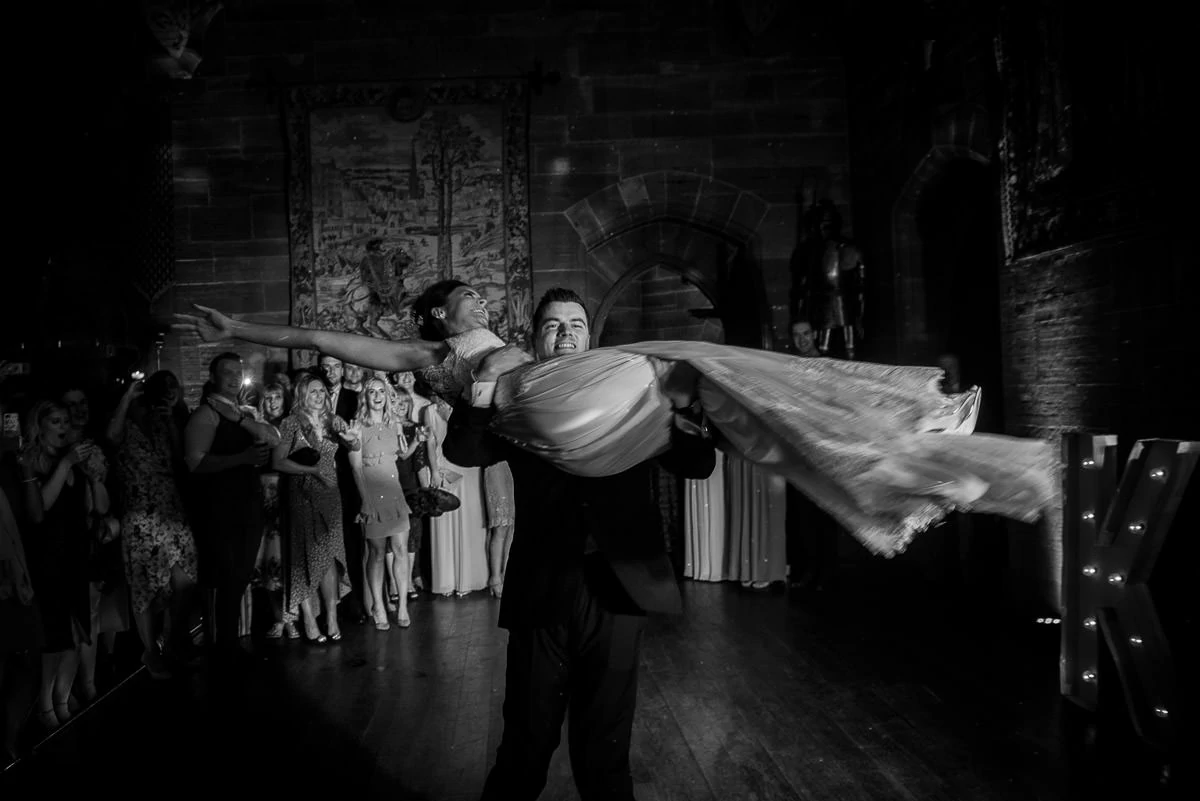 groom lifting bride during their peckforton castle first dance