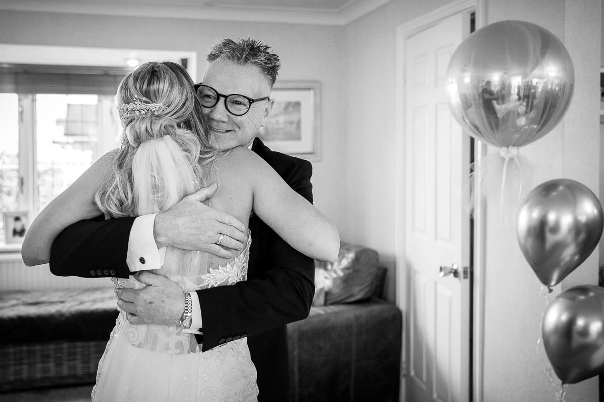 father of the bride hugging bride