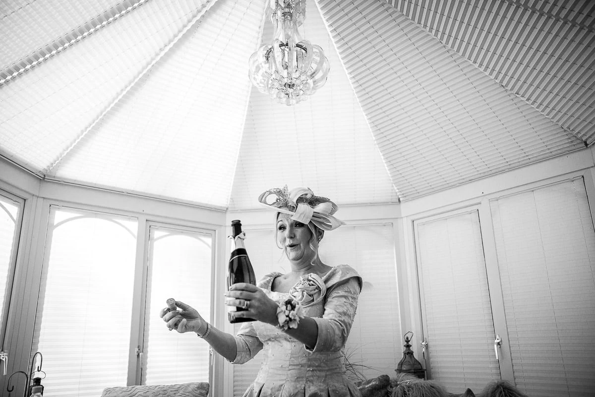motehr of the bride opening a bottle of moet