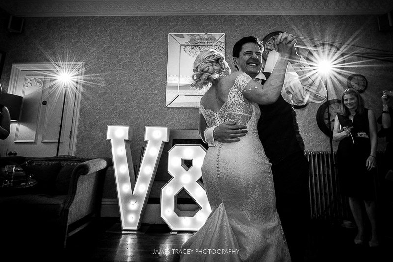 black and white photo of bride and groom dancing