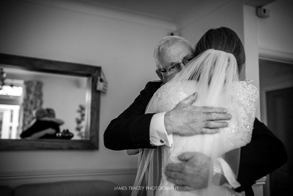 father of the bride hugging bride