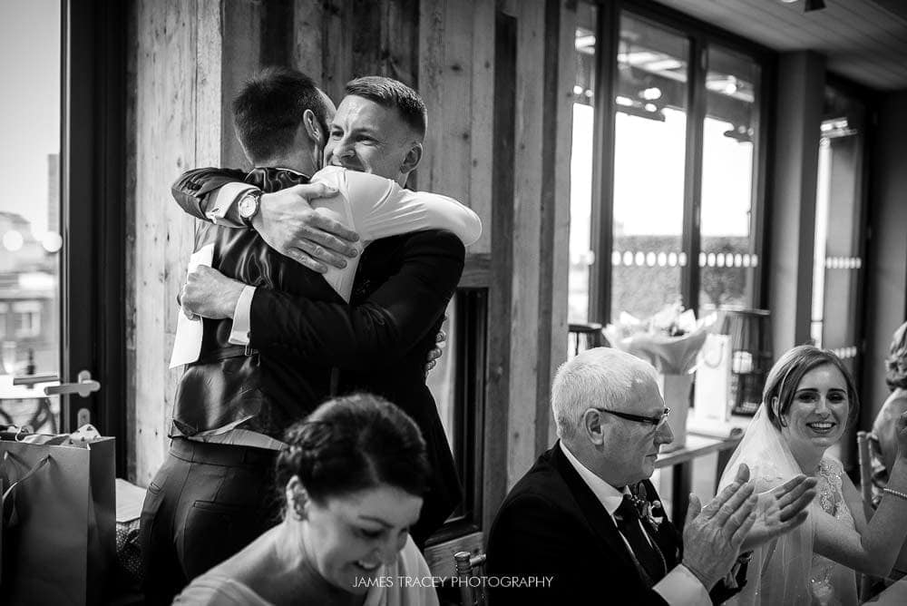 groom hugging best man