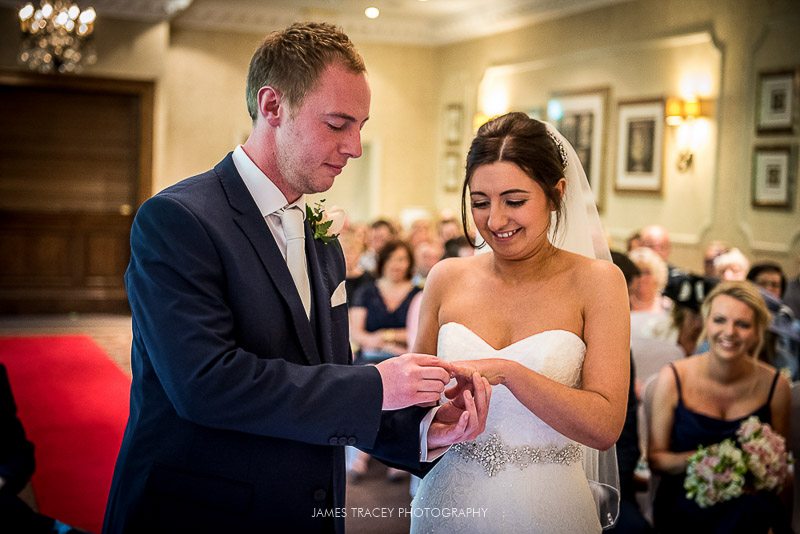 groom putting wedding ring on