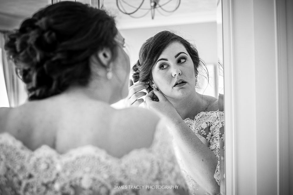 bride putting ear rings on