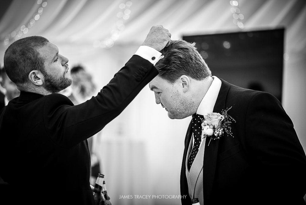 groom having confetti removed from his hair