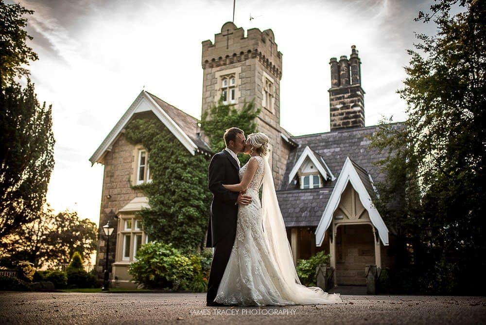 bride and groom kissing in front of west tower