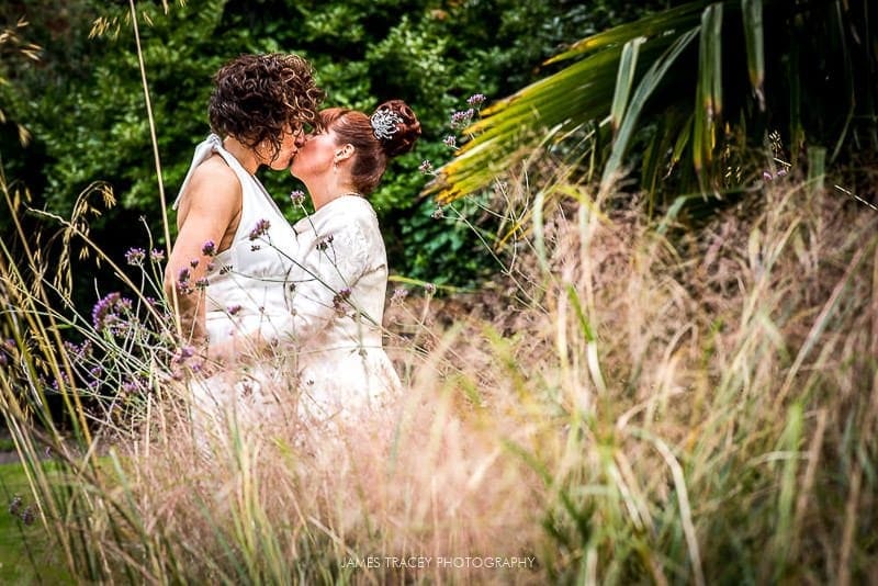 brides kissing in a park