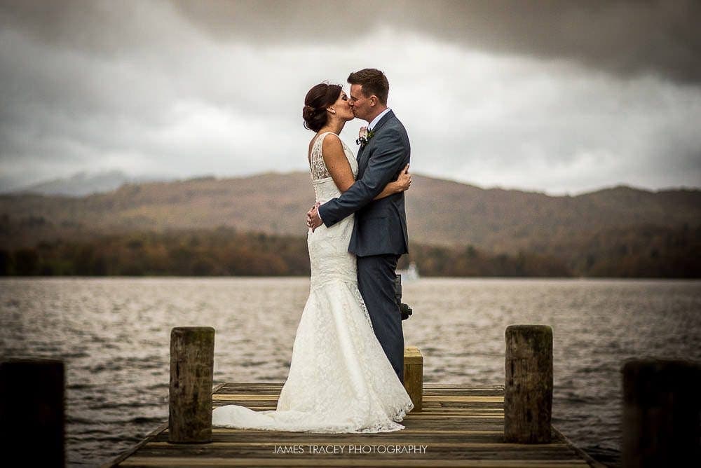 bride and groom kissing on lake windermere