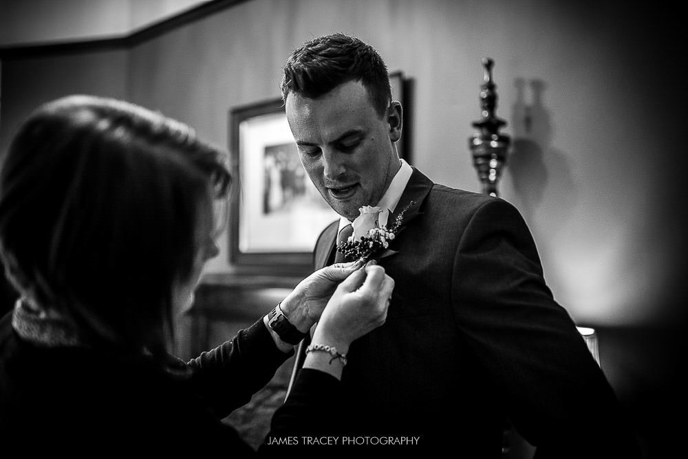 groom having flower pinned on