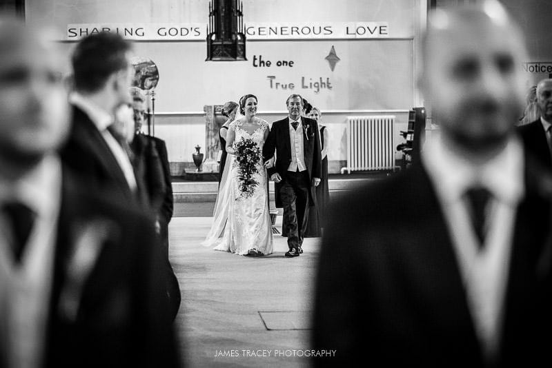 bride and her father walking up the wedding aisle