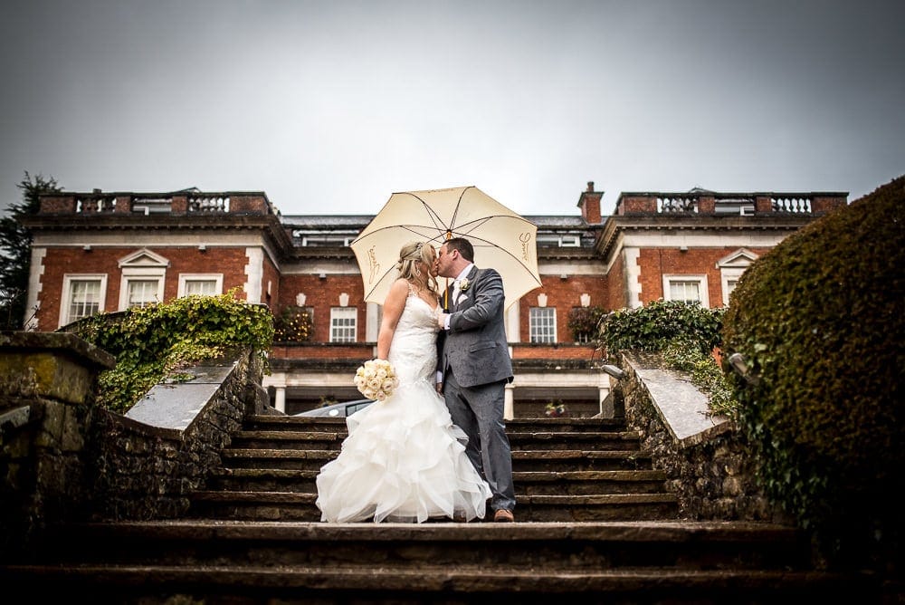 bride and groom kissing on steps at eaves hall