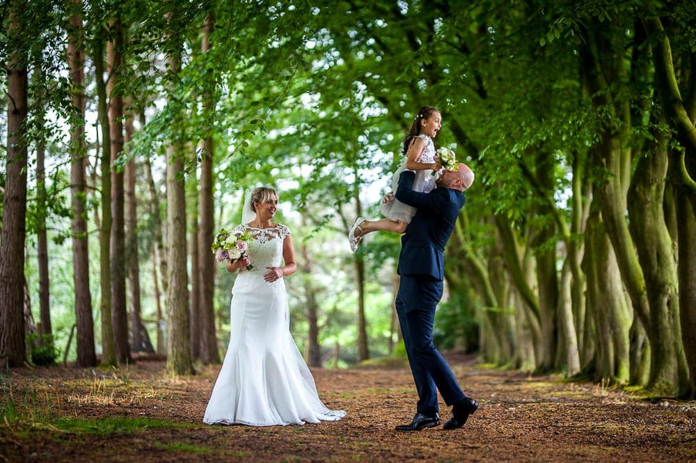 groom picking up his daughter at wedding