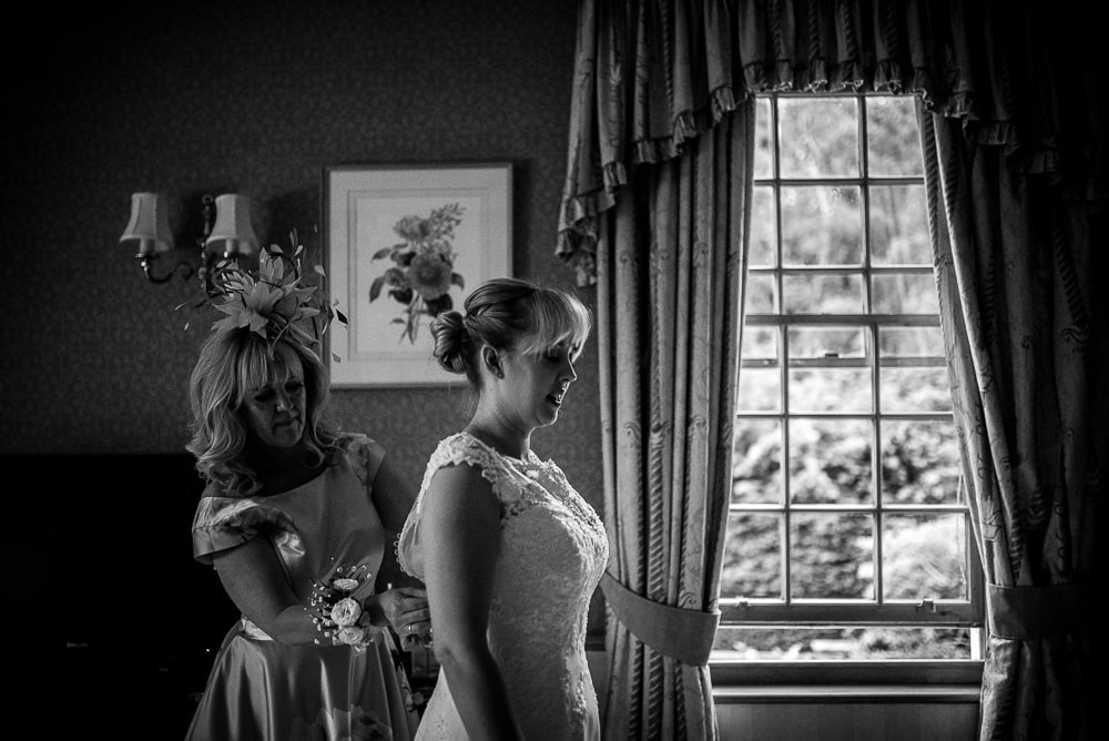 bride getting in her wedding dress