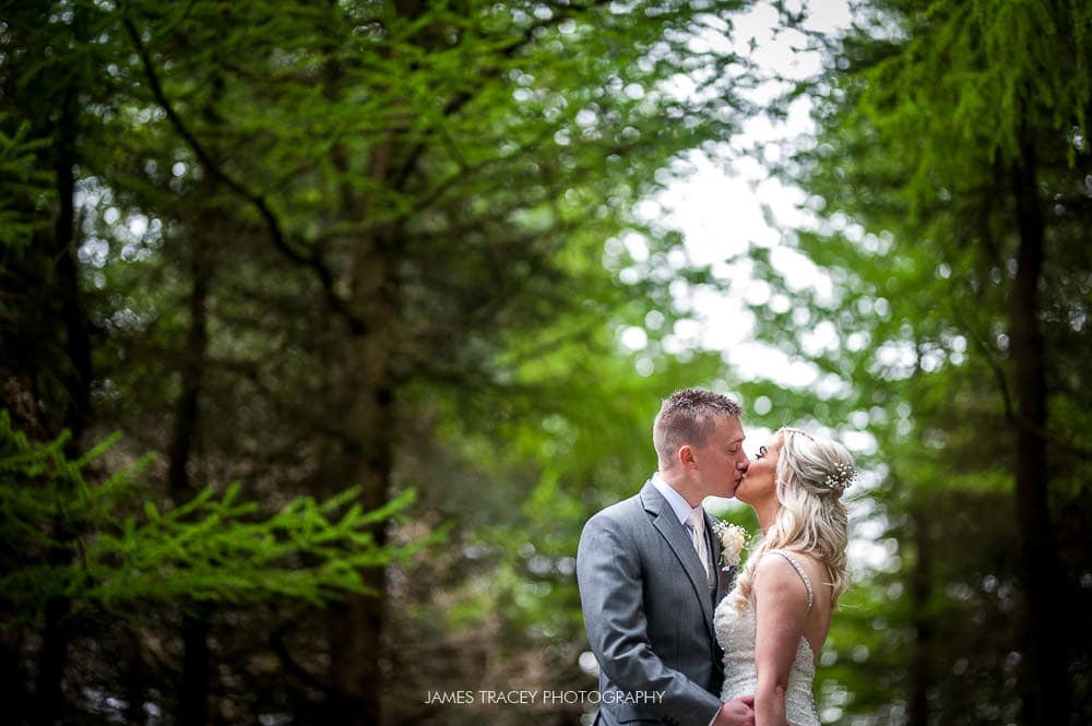 bride and groom kissing in woods