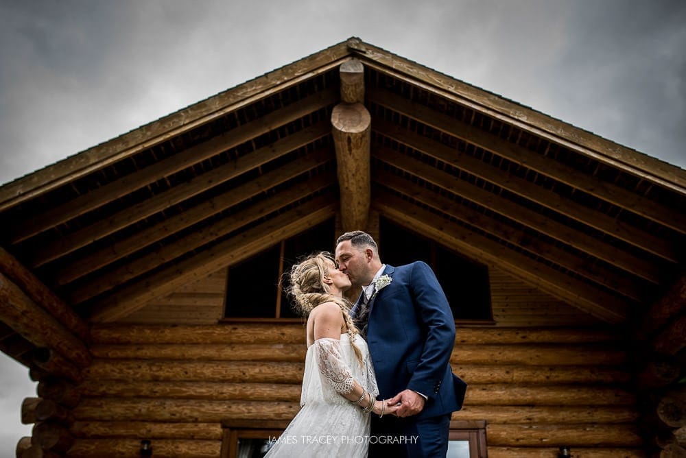 bride and groom kissing at hidden river cabin