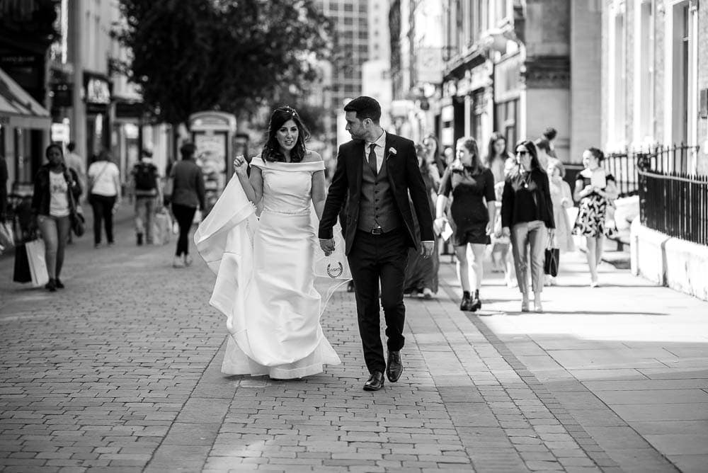 bride and groom walking through the streets of manchester