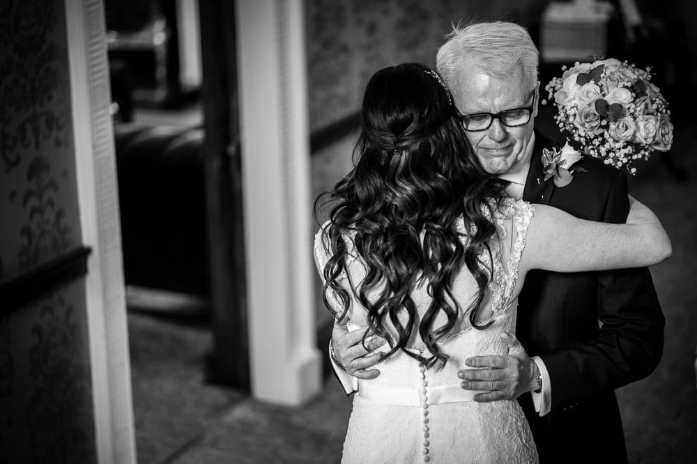 emotional father of the bride hugging daughter