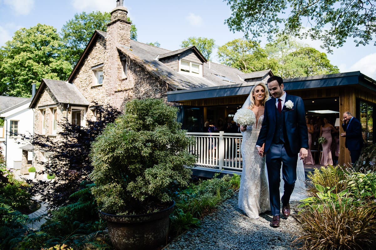 bride and groom leading guests through gilpin lake house gardens