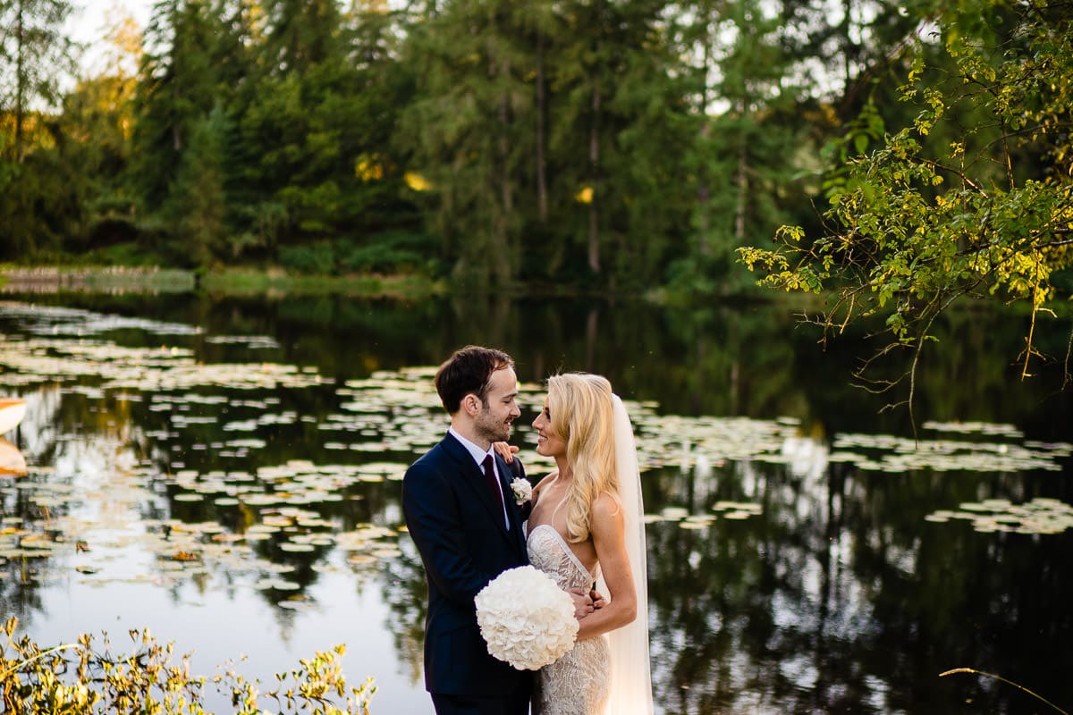 bride and groom in front of lake at gilpin lake house