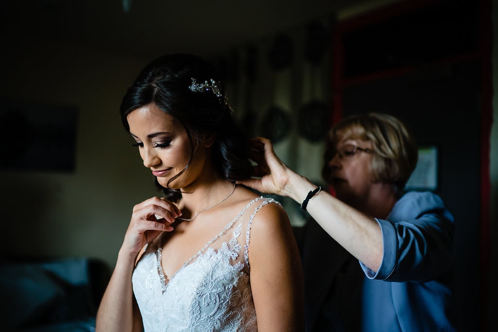 emotional bride looking at sentimental necklace on her wedding day