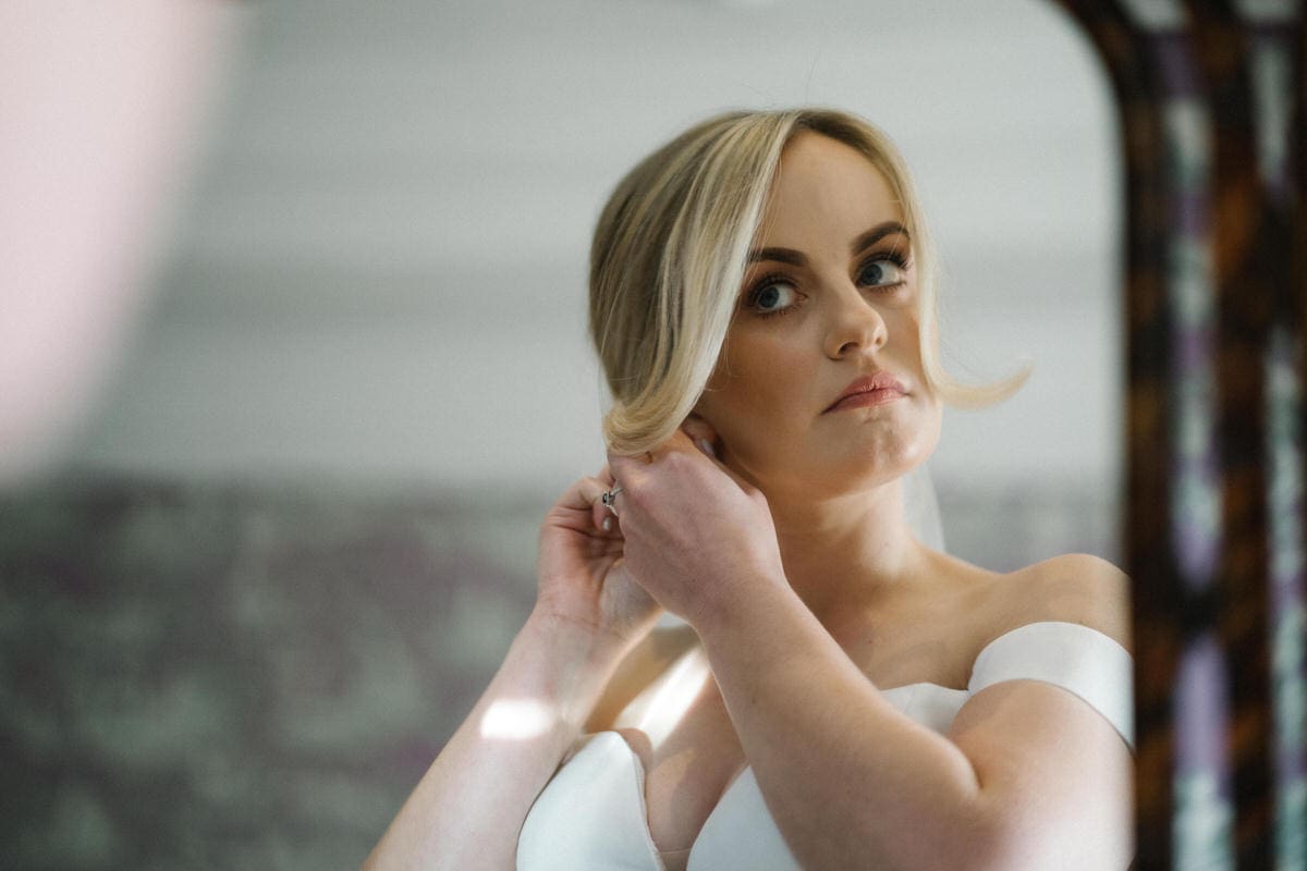 bride putting her earings in 