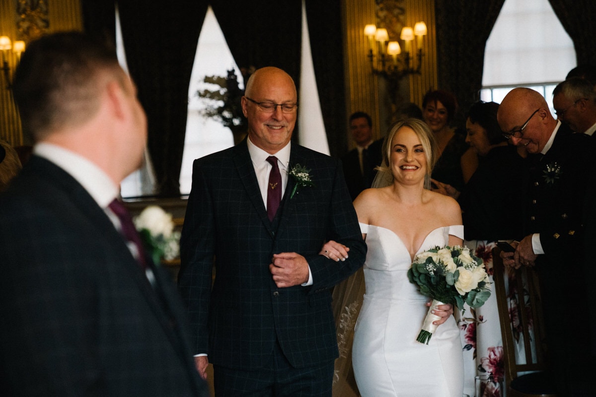 bride walking up the aisle at knowsley hall wedding