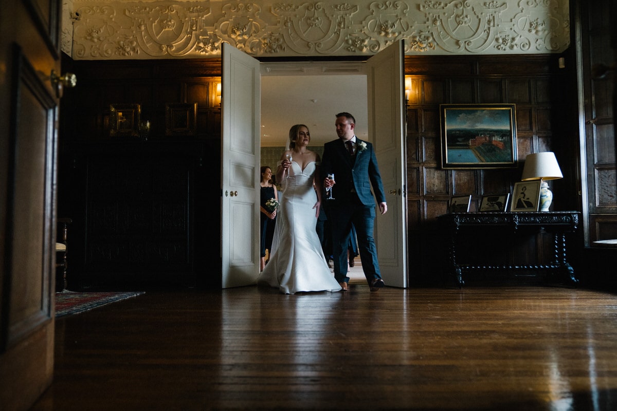 bride and groom leading their guests through knowsley hall