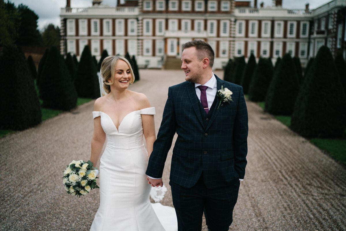 bride and groom walking on path at front of knowsley hall