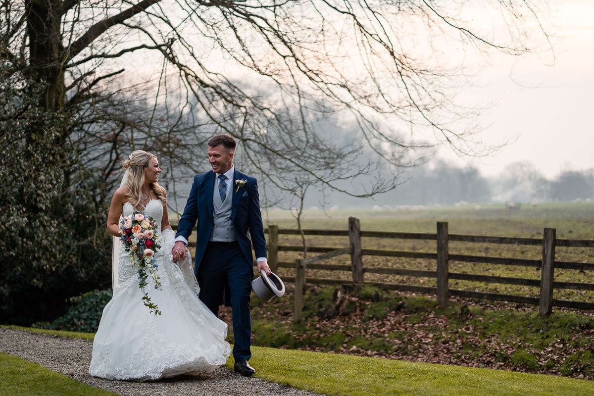 bride and groom walking at mitton hall 