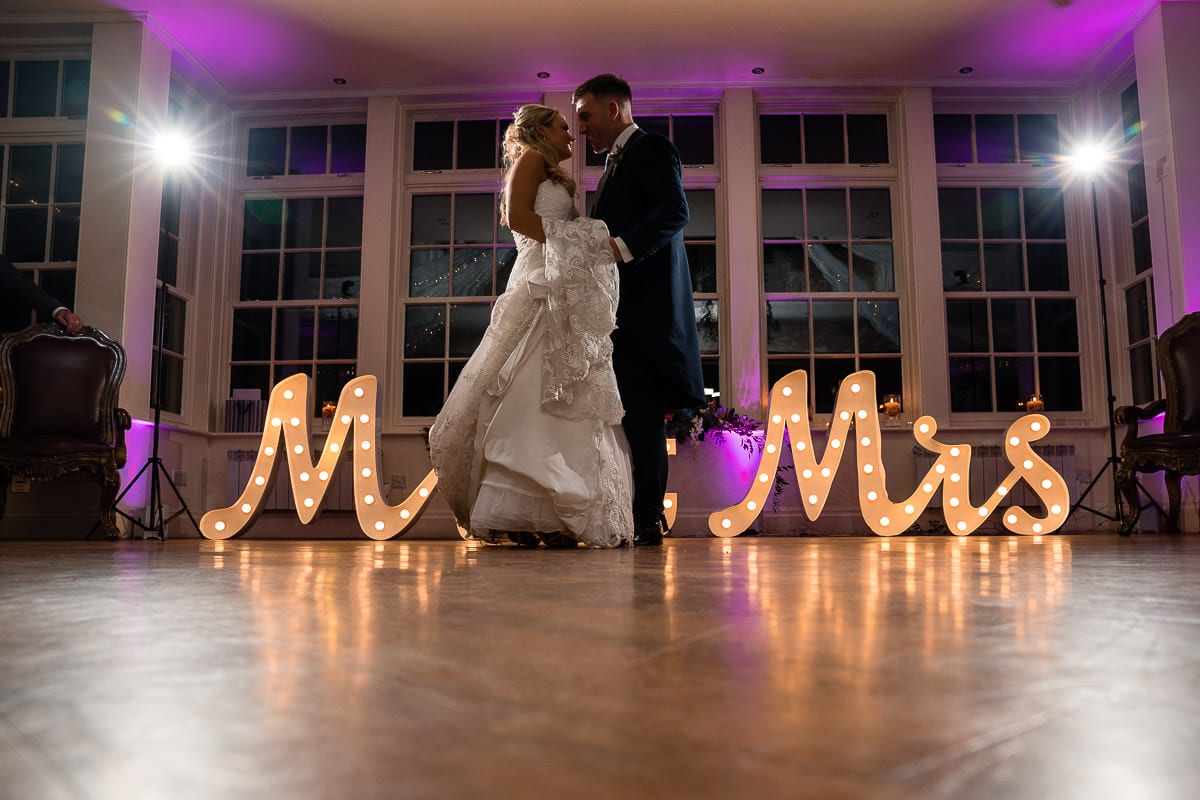 first wedding dance in front of light up mr and mrs sign