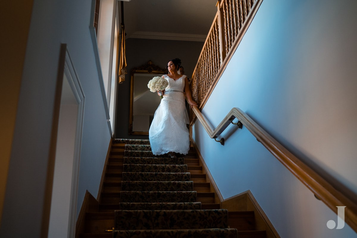 bride walking down staircase at Colshaw Hall