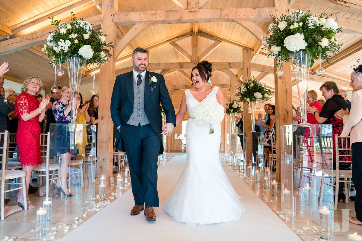 bride and groom walking back down the ailse at Colshaw Hall