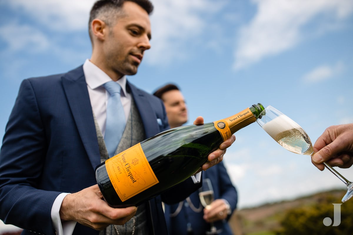 groom pouring champagne