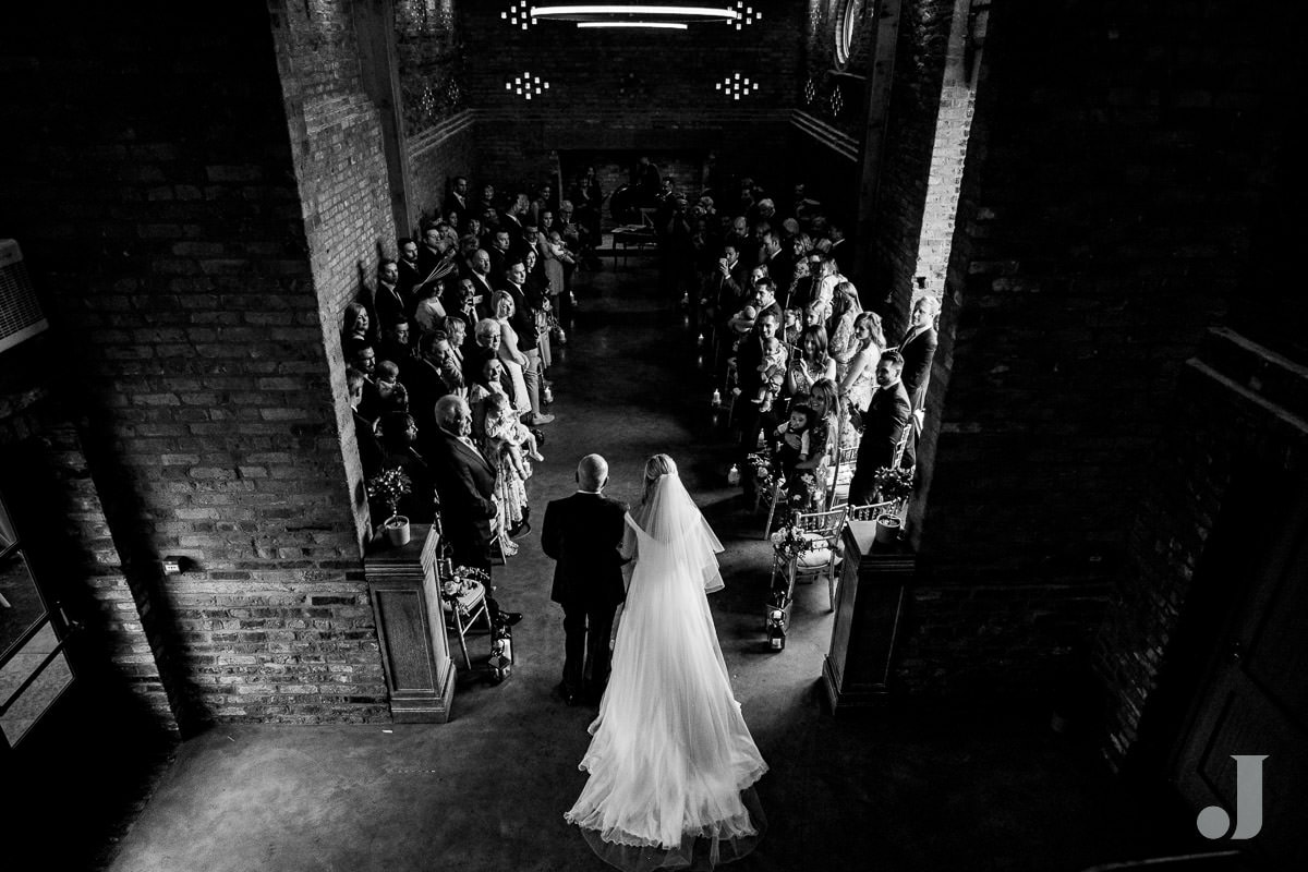 bride walking up the aisle at the holford estate from high position